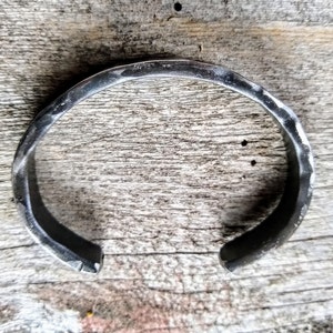 May include: A silver metal bracelet with a hammered finish.