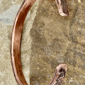 K&ouml;nnte beinhalten: Ein geh&auml;mmertes Kupferarmband mit rustikalem Finish. Das Armband ist offen und hat eine leicht gebogene Form.