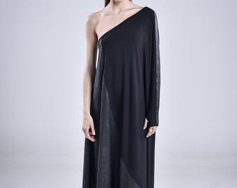 May include: A black one-shoulder dress featuring a long sleeve on one side and a contrasting textured panel. The garment has an asymmetrical hemline and is paired with black lace-up boots that reach mid-calf, creating a cohesive dark look.