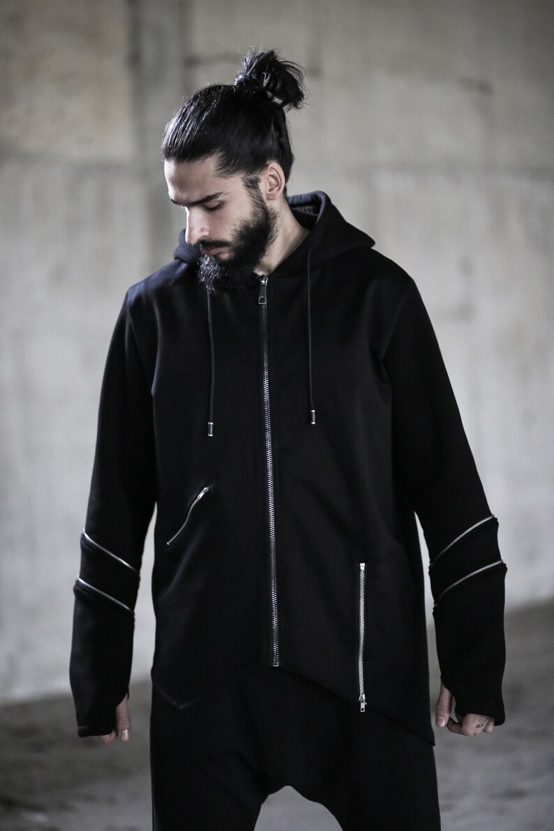 May include: A black zip-up hoodie with a long, asymmetrical hemline and zipper detailing on the sleeves.