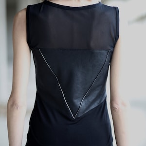 Op de afbeelding: Zwart tanktop met een mesh paneel en een lederen driehoek detail op de rug.
