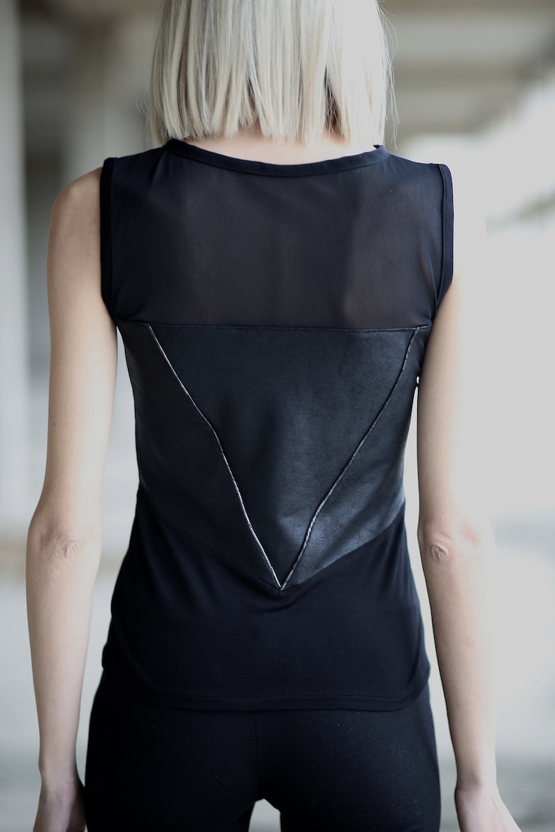 Op de afbeelding: Zwart tanktop met een mesh paneel en een lederen driehoek detail op de rug.