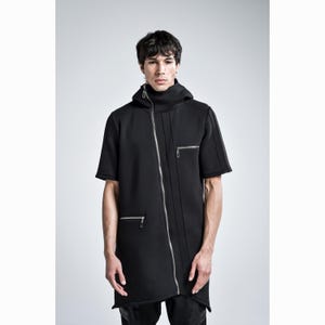 Puede incluir: Chaqueta negra de manga corta con cuello alto y capucha. La chaqueta presenta una cremallera plateada diagonal y dos bolsillos con cremallera. El dise&ntilde;o tiene una est&eacute;tica moderna y atrevida.