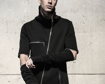 Puede incluir: Chaqueta negra asimétrica con cremallera, mangas cortas y cuello alto. La chaqueta presenta cremalleras plateadas y un diseño único, que ofrece una estética moderna y vanguardista. Mangas con detalle recortado en el codo. Prenda elegante.