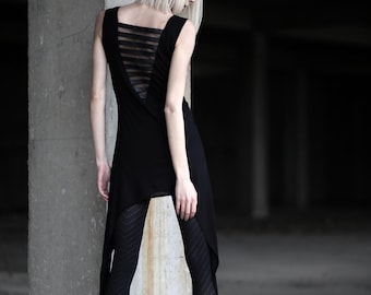 May include: A black sleeveless tunic featuring a back panel with horizontal sheer stripes and an asymmetrical hemline, paired with black patterned leggings and black ankle boots. The garment has a square neckline and a fitted bodice.