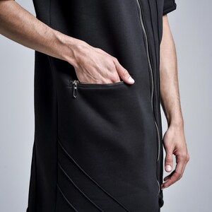 Puede incluir: Top negro estilo t&uacute;nica con cierre de cremallera y bolsillo con cremallera. El top tiene mangas cortas y detalles de costura decorativos. El modelo lleva el top. El top est&aacute; hecho de un material suave y c&oacute;modo.