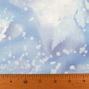 May include: Light blue fabric with a watercolor effect. The fabric features white leaf and dot patterns, creating a soft, airy design. The fabric is suitable for various craft projects.