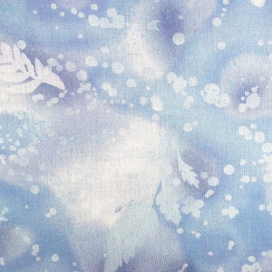 May include: Abstract textile design in shades of blue and white. The fabric features a watercolor-like effect with soft, blurred shapes and scattered white dots. Delicate leaf-like patterns are also visible, creating a serene, nature-inspired aesthetic.