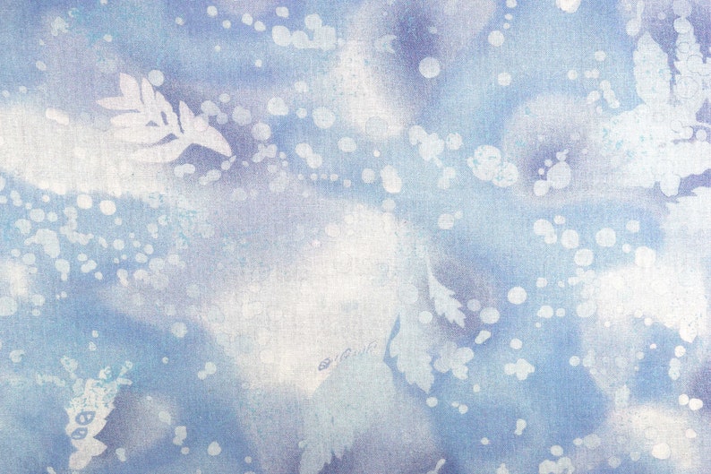 May include: Abstract textile design in shades of blue and white. The fabric features a watercolor-like effect with soft, blurred shapes and scattered white dots. Delicate leaf-like patterns are also visible, creating a serene, nature-inspired aesthetic.