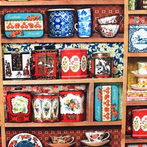 May include: A wooden shelf unit with multiple shelves filled with vintage tea tins, teacups, and other decorative items. The tins are decorated with floral patterns, geometric designs, and images of birds and flowers. The teacups are in various colors and patterns, including blue and white, red and white, and floral patterns. The shelf unit is painted in a light wood color and has a rustic look.