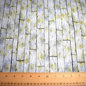 May include: Fabric with a wood plank design. The pattern features vertical planks in shades of gray and white, with yellow accents in the wood grain. The fabric is suitable for various craft projects.