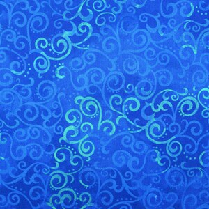 May include: A close-up of a blue fabric with a swirling, ornate pattern. The design features light blue and teal-colored curls and dots against a deep blue background. The fabric has a textured appearance.