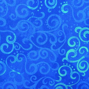 May include: Close-up of a blue fabric with a repeating pattern of swirling, scroll-like designs in a lighter shade of blue. The fabric has a textured appearance, with the lighter blue designs appearing to be painted on top of the darker blue background.