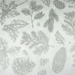 May include: White fabric with a silver glitter pattern of pine branches, holly leaves, and pine cones.