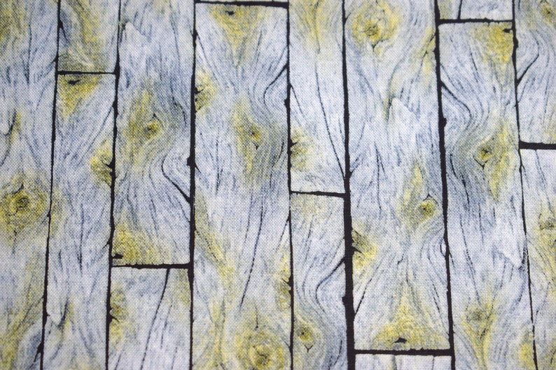 May include: Close-up of a fabric with a wood grain pattern. The design features vertical planks in shades of gray, yellow, and black. The fabric has a textured appearance, with the wood grain details clearly visible.
