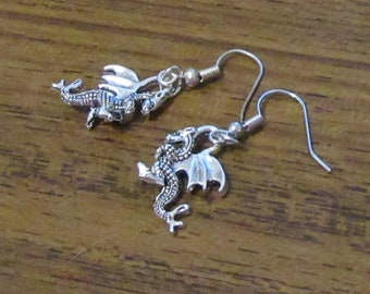 Peut inclure: Une paire de boucles d'oreilles en argent en forme de dragon avec un pendentif en forme de dragon. Les boucles d'oreilles sont en métal et ont une fermeture à crochet.