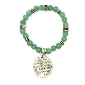 May include: Green gemstone beaded bracelet with a silver charm that reads "may you always have a shell in your pocket & sand between your toes".