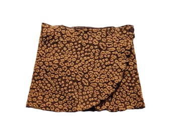 May include: A brown and tan mini skirt with a leopard print pattern. The skirt is made of a soft, textured fabric.