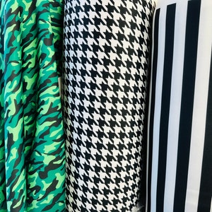 May include: Three fabric swatches, one with a green camouflage pattern, one with a black and white houndstooth pattern, and one with black and white vertical stripes.