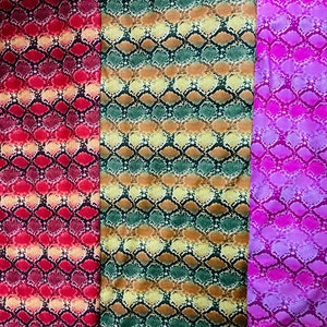 May include: Three fabric swatches with a snake skin pattern. The swatches are red, green, and purple.