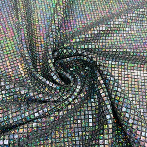 May include: Black fabric with a silver iridescent square pattern. The fabric is folded and shows the texture of the material.