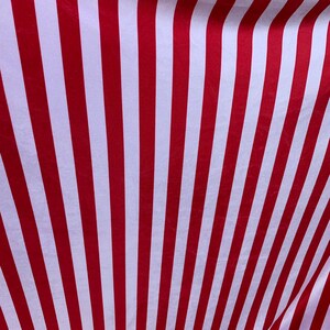 May include: Red and white striped fabric with a subtle sheen. The fabric is folded and draped, creating a wavy pattern.