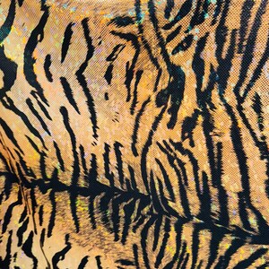Puede incluir: Primer plano de una tela de estampado de tigre marr&oacute;n y negro con un acabado brillante.
