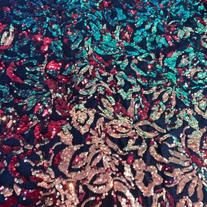 May include: A fabric with a floral pattern made of iridescent sequins in shades of teal, pink, and red on a black background.