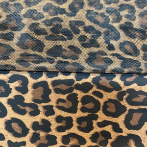 May include: Two pieces of fabric with a leopard print pattern. The top piece is a sheer mesh fabric with a brown background and black spots. The bottom piece is a solid fabric with a brown background and black spots.