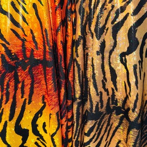 Puede incluir: Primer plano de una tela con estampado de tigre. La tela es naranja, negra y amarilla con un acabado brillante.