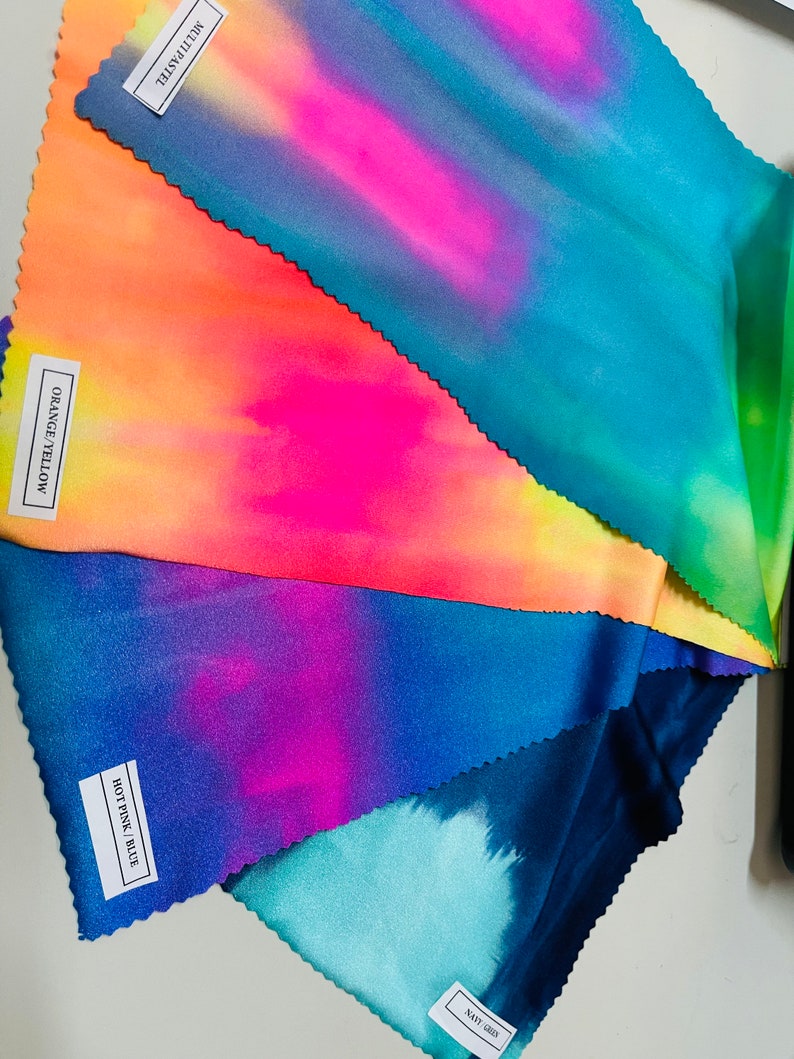 May include: Five fabric swatches with tie-dye patterns in shades of blue, pink, orange, yellow, and green. The swatches are labeled with the color names: "Navy Grey", "Hot Pink/Blue", "Orange/Yellow", and "Multi Pastel".