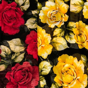 May include: A black fabric with a floral print featuring red and yellow roses. The roses are large and detailed, with a realistic appearance.