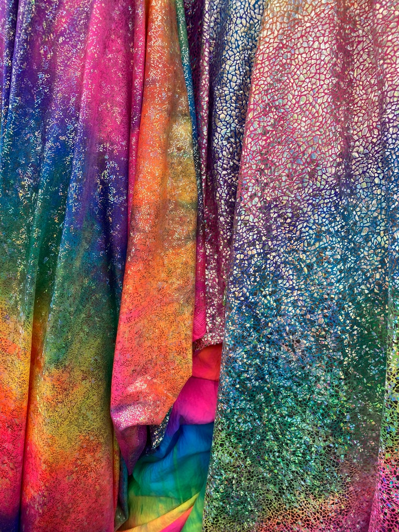 K&ouml;nnte beinhalten: Drei irisierende Stoffe mit einem Regenbogen-Farbverlauf. Der Stoff links hat einen Batik-Effekt, der Stoff in der Mitte hat eine schimmernde Oberfl&auml;che und der Stoff rechts hat eine strukturierte, irisierende Oberfl&auml;che.