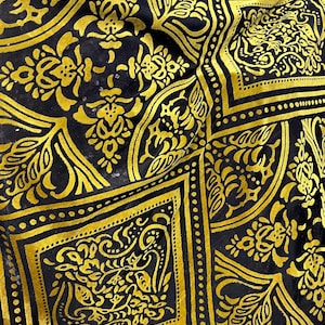 May include: Black fabric with a gold patterned design. The pattern features intricate floral and geometric shapes.