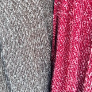 K&ouml;nnte beinhalten: Nahaufnahme von zwei Stoffproben, eine grau und eine rot, mit einem wei&szlig;en, gefleckten Muster. Der Stoff hat eine strukturierte, gestrickte Optik.