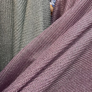 Puede incluir: Dos piezas de tela, una es gris claro y la otra es morado oscuro. Ambas telas tienen un patr&oacute;n de punto texturizado brillante.