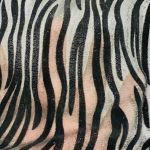 May include: Black and white zebra patterned sheer fabric with a soft, velvety texture.