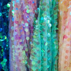 Puede incluir: Cuatro telas iridiscentes de diferentes colores con lentejuelas. La tela es una malla transparente con lentejuelas redondas.