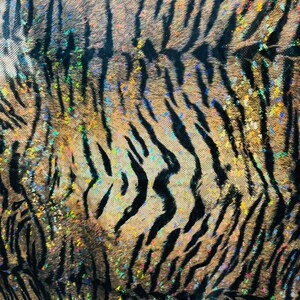May include: Close-up of a fabric with a tiger stripe pattern. The fabric is brown and black with a glittery finish. The glitter is iridescent and has a rainbow effect.