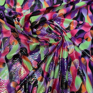 May include: A colorful fabric with a snakeskin pattern and abstract shapes in shades of pink, green, purple, and orange.