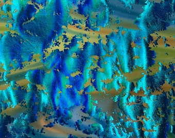 May include: Turquoise fabric with a metallic, iridescent, abstract pattern. The fabric has a textured, slightly rough surface. The fabric is labeled "TURQUOISE".