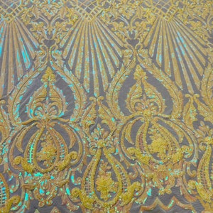 May include: Yellow iridescent sequins on a mesh fabric with a damask pattern. The sequins are arranged in a repeating pattern of swirls and leaves.
