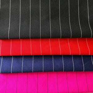 May include: Close-up of four fabric swatches in black, red, navy blue, and hot pink. Each swatch has vertical white pinstripes. The fabrics are layered, showcasing the different colors and patterns.