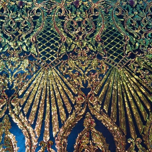 May include: Black fabric with a gold and green iridescent sequin pattern. The pattern features a damask design with a repeating floral motif.