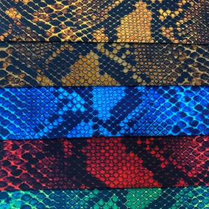 May include: Five fabric swatches with a snake skin pattern. The swatches are in the colours brown, black, blue, red, and green.