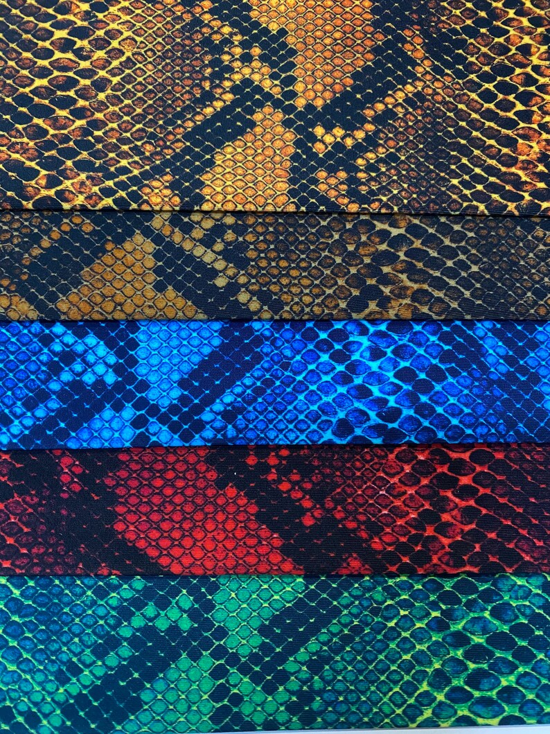 May include: Five fabric swatches with a snake skin pattern. The swatches are in the colours brown, blue, red, green, and black.