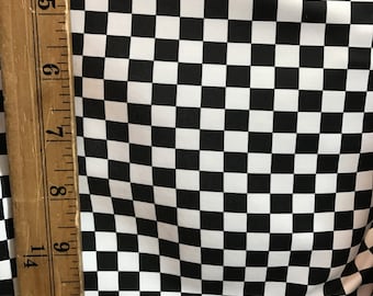May include: Black and white checkered fabric with a ruler measuring 11 inches.