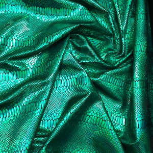 Könnte beinhalten: Grüner Stoff mit Schlangenhautmuster. Der Stoff ist zerknittert und hat eine glänzende, irisierende Oberfläche.