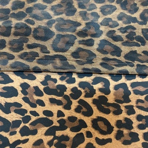 May include: Two pieces of fabric with a leopard print pattern. The top piece is a sheer mesh fabric with a brown and black leopard print. The bottom piece is a solid fabric with a brown and black leopard print.
