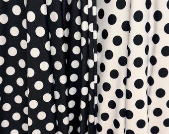 May include: Close-up of three fabric panels with a polka dot pattern. The panel on the left is black with white dots, the middle panel is black with white dots, and the panel on the right is white with black dots. The fabric is draped.